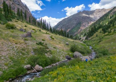 Anglers walking along high mountain stream in San Juan National Forest.